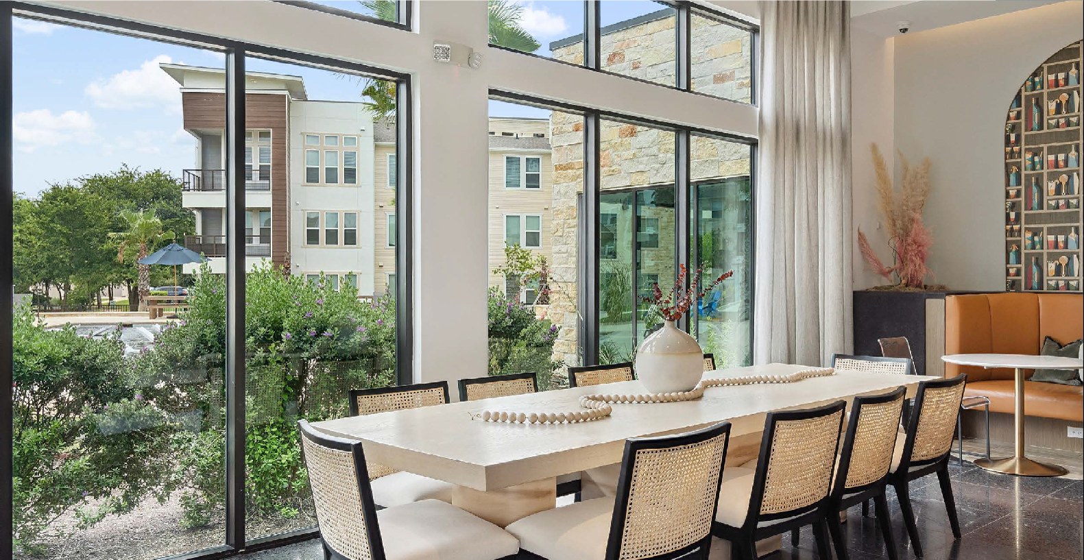 Resident clubhouse dining room with floor-to-ceiling windows overlooking the community