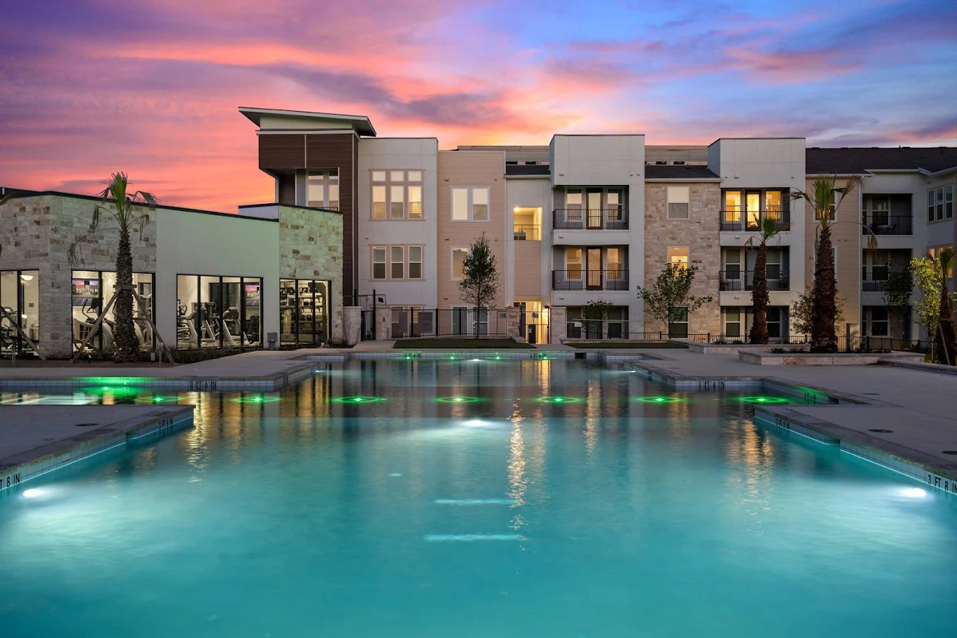 Class A apartment community with a pool at dusk